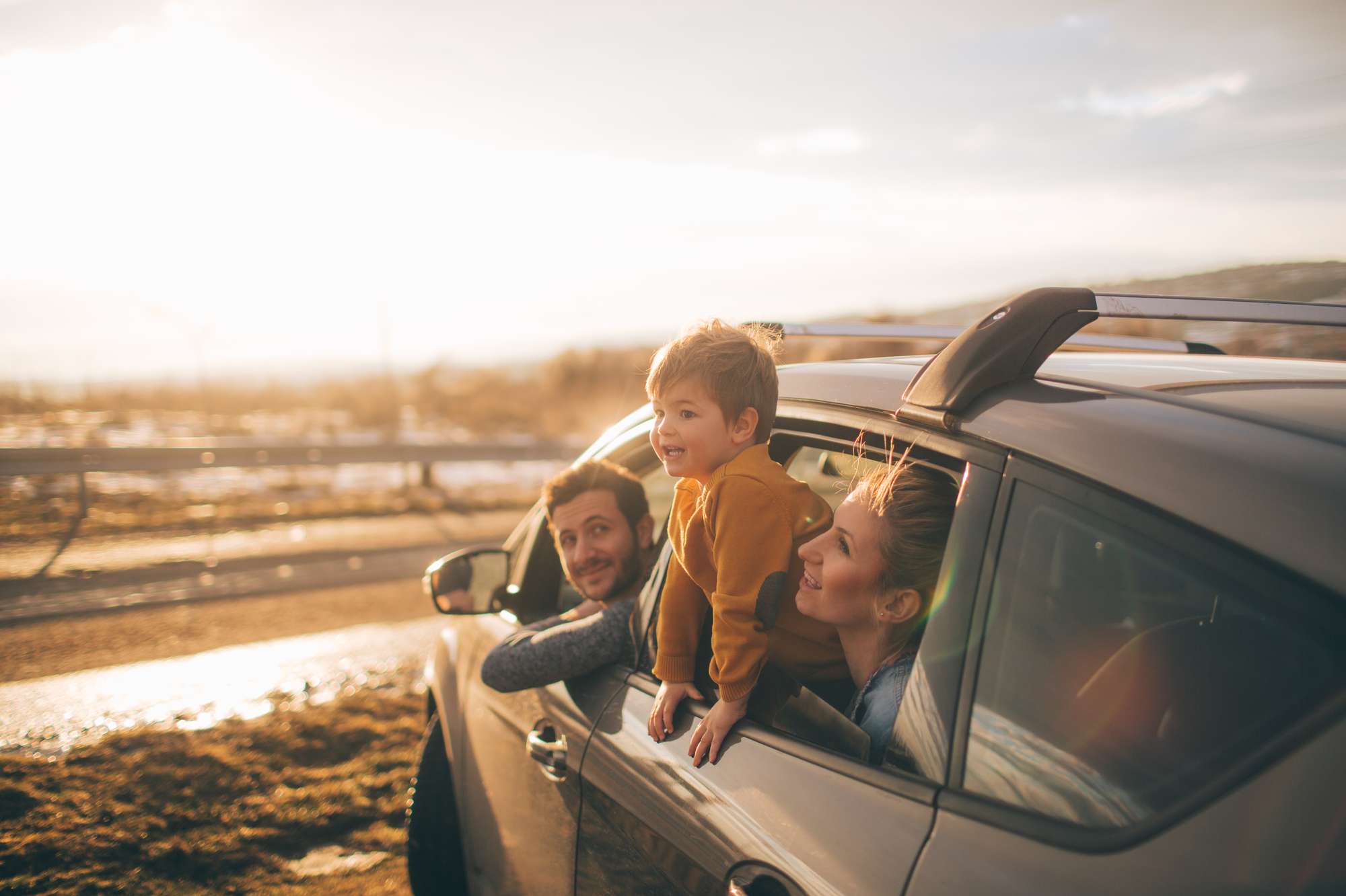 En glad familj i en bil iväg på äventyr.
